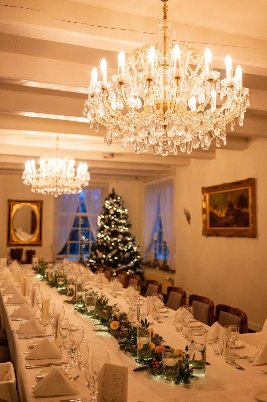 Gedekte kersttafel met kroonluchter en kerstboom